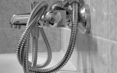 Un robinet de douche avec tuyau flexible accroché au mur