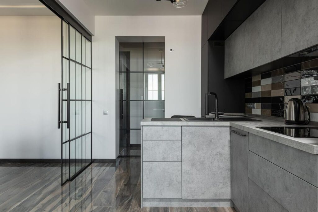 Cuisine moderne avec îlot central et porte coulissante vitrée