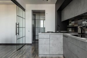 Cuisine moderne avec îlot central et porte coulissante vitrée